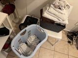 a laundry basket full of towels and other items on the floor