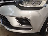 a close up of a white car that is parked in a garage