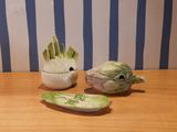 two ceramic figurines of vegetables sitting on a table