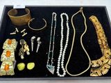 un plateau noir sur lequel sont disposés divers bijoux