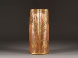 a brown vase with a gold design on it