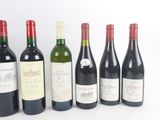 six bottles of wine are lined up in a row on a table