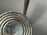 an antique silver plated candle holder with a candle in the middle of it
