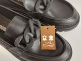 pair of black leather shoes with a brown tag on them