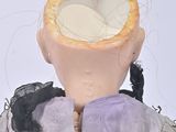 a doll that has a piece of bread on it ' s head