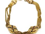 une image représentant un bracelet en or orné de perles noires sur fond blanc