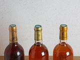 three bottles of wine sitting on a table next to each other