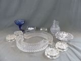 de nombreux objets en verre posés sur une table, sur fond gris