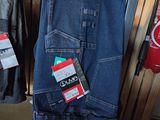 several pairs of jeans hanging on a rack in a store