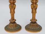 pair of antique brass candlesticks with figures on each of them