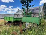 un camion-benne vert garé devant une maison