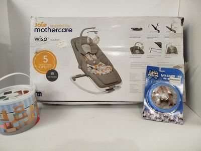 une boîte contenant un berceau pour bébé et d'autres objets, posée sur l'étagère