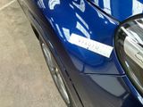 a blue car with a sticker on it parked in a parking lot