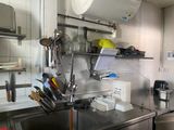 une cuisine avec des plans de travail en inox et un évier