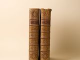 deux vieux livres posés l'un sur l'autre sur une table