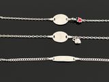 four different types of silver bracelets on a black surface