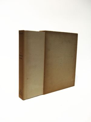 an old book sitting on top of a white table next to a white wall