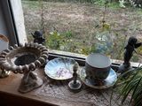 un rebord de fenêtre sur lequel sont disposés de nombreux vases et autres objets