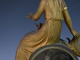 a statue of a woman sitting on top of a clock