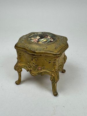 a small gold box with a picture on it