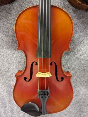 un gros plan d'un violon posé sur un tapis