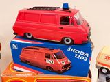 three toy cars and a toy bus on top of each other
