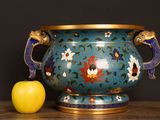 a blue vase and an apple sitting on a table