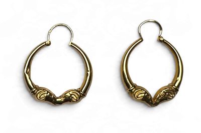 une paire de boucles d'oreilles anciennes en laiton sur fond blanc