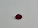 a red stone sitting on a white surface in the snow