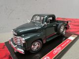 une maquette de camion vert posée sur un présentoir