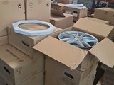 a pile of cardboard boxes and a toilet in a warehouse
