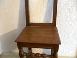 une petite chaise en bois avec une assise en bois, posée sur une table