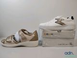 deux paires de baskets blanches et dorées, avec leur boîte
