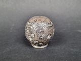 an image of a small silver object on a black surface