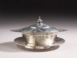 an antique silver plate with a lid and a saucer on a saucer