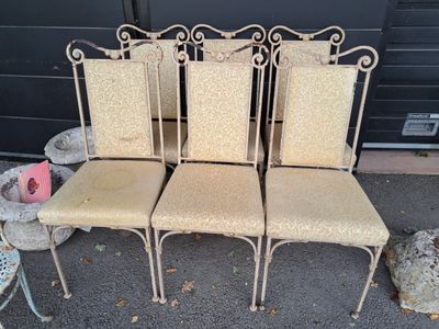 quatre chaises sont alignées en rang sur le trottoir