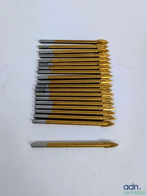 de nombreux crochets dorés et argentés disposés sur un fond blanc