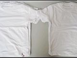 two white t - shirts sitting next to each other on top of a table