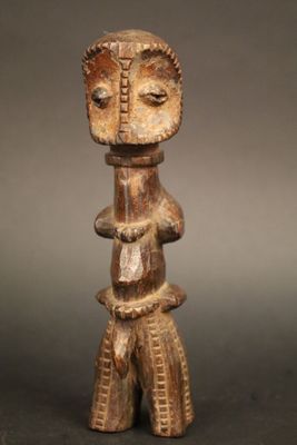 une statue en bois représentant un homme avec un visage et des jambes