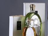 three bottles of perfume sitting on top of a table next to a box