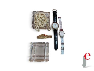 a watch, bracelets, and other items on a white surface