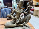 a statue of a woman playing a musical instrument on a table