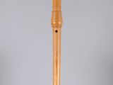 a wooden flute on a clear stand with a white background