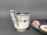 pair of antique porcelain cups and saucers with hand painted floral designs