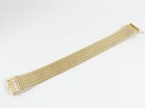 un bracelet en maille dorée sur fond blanc