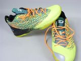 a pair of yellow and green shoes with orange laces on them
