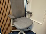 une chaise de bureau grise placée devant une porte