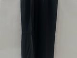 a black pants hanging on a hanger against a white wall