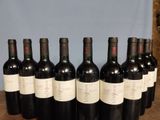 six bottles of wine are lined up on a wooden table