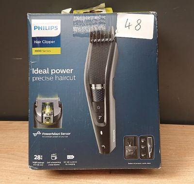 La tondeuse à cheveux Philips se trouve dans la boîte posée sur la table
